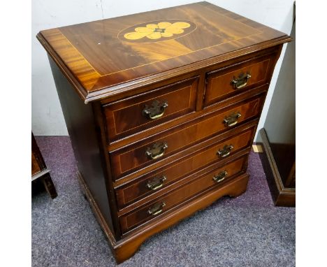 A small reproduction bachelor's chest of two over three drawers, satinwood flower head patera, brass batwing escutcheons with