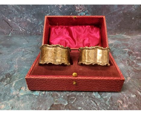A pair of silver napkin rings, C and S scroll borders, Sheffield 1904, cased 