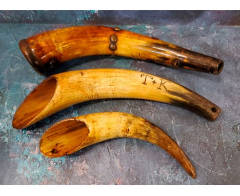 A late 18th century drinking horn, with brass studs, 35cm long;&nbsp; another, inscribed T + K, 34cm long;&nbsp; another (3) 