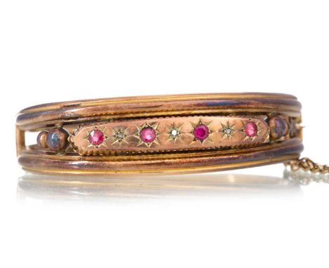 RUBY AND DIAMOND BANGLE EARLY 20TH CENTURY set with four round rubies spaced by diamond chips, in nine carat gold6cm wideQty: