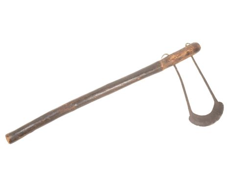 A West African tribal axe having the upper portion carved with geometric shapes and blade tangs tapering to form a crescent s