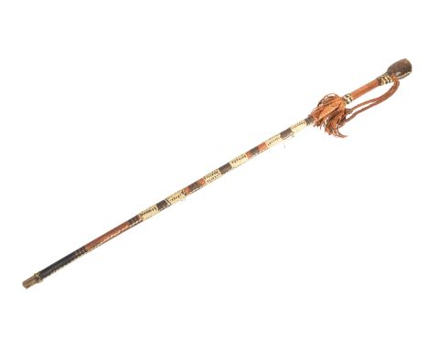 A vintage African / Zulu tribal walking stick cane with a leather clad pommel, plaited carry strap, tasselled collar and blac
