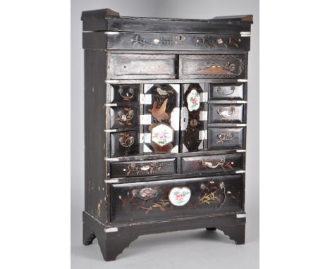 A Japanese black lacquer Kodansu table top cabinet with inset porcelain plaques. Meiji period 1868 - 1912. With brass mental 