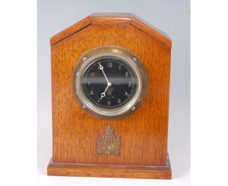 An early 20th century Smiths oak cased mantel clock, having a black enamel dial with Arabic numerals, the case with applied I