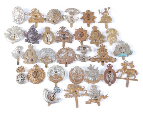 A collection of cap badges and insignia to include Cornwall, Royal Lincolnshire, Royal Engineers, Hampshire, Royal Army Ordna