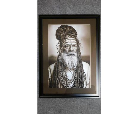 A framed and glazed monochrome photographic portrait of an elder tribesman. 90x67cm 