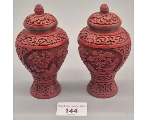 Pair of Chinese Cinnabar temple vases with covers decorated with a floral design. 12.5cm height. 