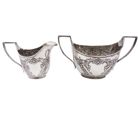 Late Victorian silver milk jug and twin handled open sucrier, each of oval form with angular handles and embossed floral, fol