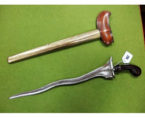 A XX Century Kris, with carved handle in wooden and brass scabbard. 