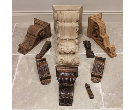 A quantity of carved architectural wall brackets, of typical form in various woods, sizes and designs, the largest 53cm high 