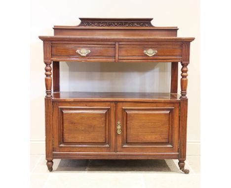 A late Victorian walnut dumb waiter, with a scrolling leaf carved pediment over two frieze drawers, raised upon baluster turn