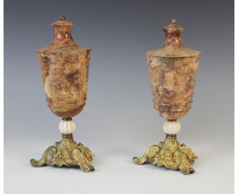 A pair of Grand Tour turned stone urns, 19th century, the bodies possibly red serpentine of conical form with ribbed detail a