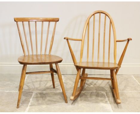 An Ercol blonde elm and beech wood stick back rocking chair, the hoop back above a shaped seat upon cylindrical tapering supp