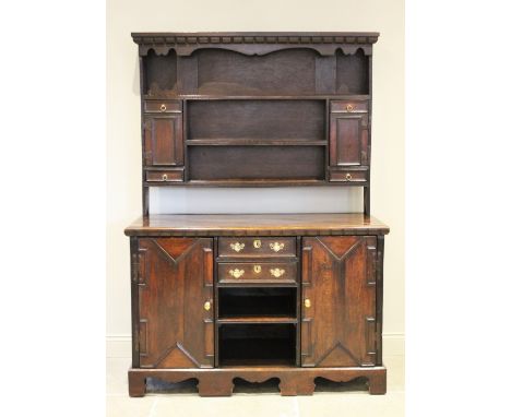 An 18th century and later assembled oak dresser and associated rack, with an arrangement of two small drawers and two geometr