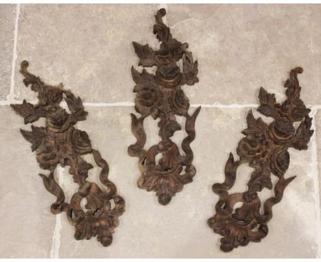Three carved wooden architectural panels modelled as garland hanging floral and foliate bouquets, each 62cm high (3) 