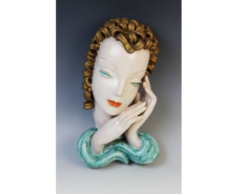 An Art Deco Goldscheider wall mask, early 20th century, modelled as a lady with gold curled hair and a turquoise scarf, print