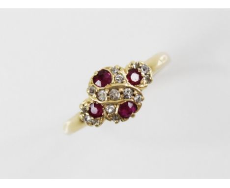 An Edwardian ruby and diamond 18ct gold ring, the quatrefoil head set with four untested round mixed cut rubies and fifteen r