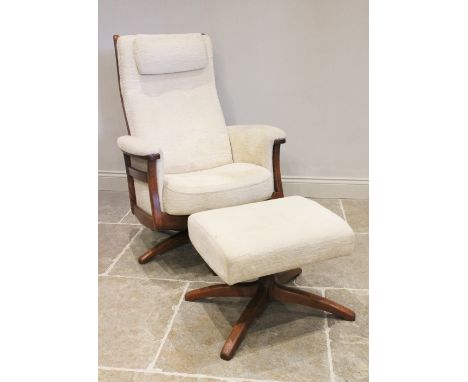 A late 20th/early 21st century Ercol studio open armchair and foot stool, with fitted cushions raised upon a revolving and re