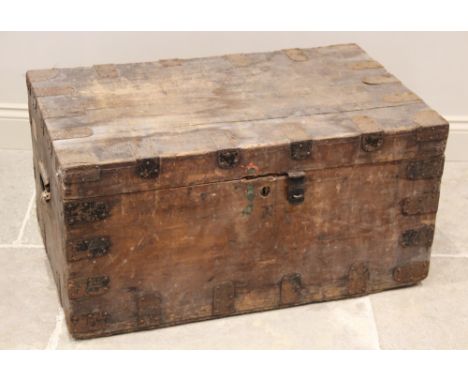 A 19th century pine trunk, applied with metal corner brackets, iron clasp and side swing handles, opening to a vacant interio