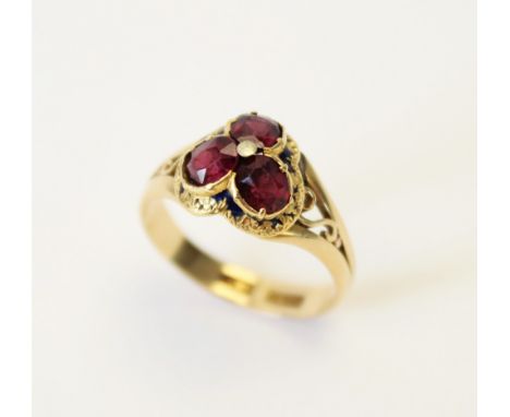 A Victorian garnet and enamel 18ct gold ring, the trefoil shaped head set with three oval old cut garnets, (each measuring 5m