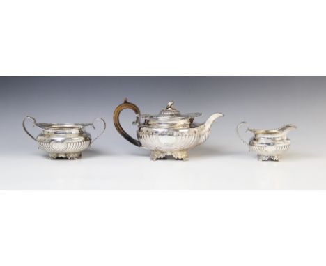 A George III silver three piece tea service by Joseph Angell I, London 1815, comprising teapot, milk jug and sucrier, each of