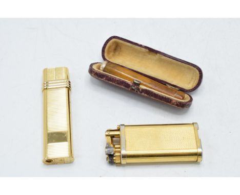 Cased cheroot holder with gold rim, a Dunhill gilt metal lighter with a Monic lighter (3).  Soldered repair to Dunhill.