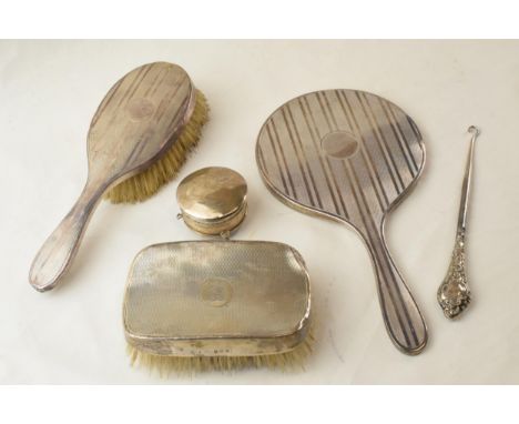 A collection of silver items to include a silver framed mirror, brushes, a trinket box (lid detached) and a button hook.  