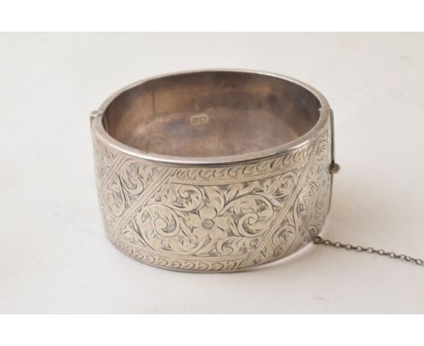 Silver wide engraved bangle with floral decoration, Chester 1957, 52.2 grams.  Dent to rear.