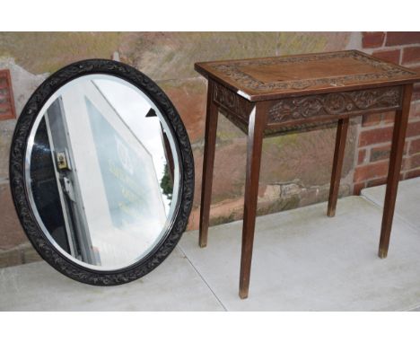 Vintage 1930s oak side table with carved decoration together with am ebonised carved oval mirror, 72cm tall (2).  Collection 