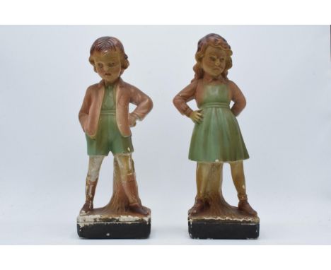 A pair of 1930s plaster Art Deco figures, with registration numbers to the reverse, 31cm tall (2).  Some loss of paint / chip