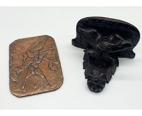 A black forest shelf with bird motif along with arts and crafts copper panel depicting a swallow