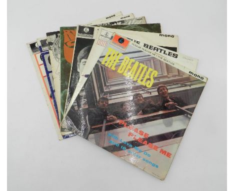 A collection of Beatles 12" vinyl record albums, including 'Please Please Me', 'Help', 'With The Beatles', 'Rubber Soul', 'Re