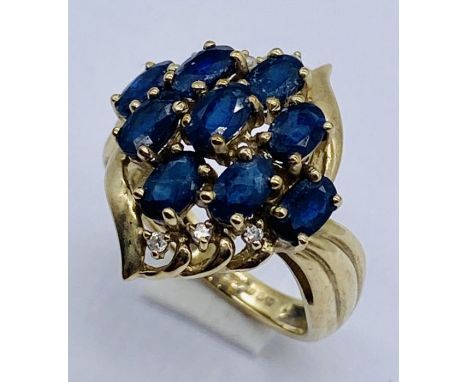 A 9ct gold dress ring set with sapphire coloured stones and diamonds