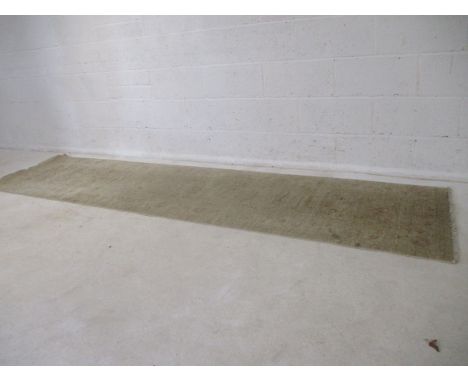 A cream coloured carpet runner. L 304cm, W 75cm