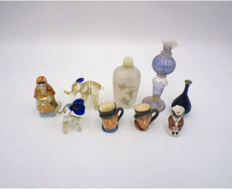 An Oriental painted glass scent bottle, along with three miniature toby jugs, some Royal Doulton, glass elephants, small cera