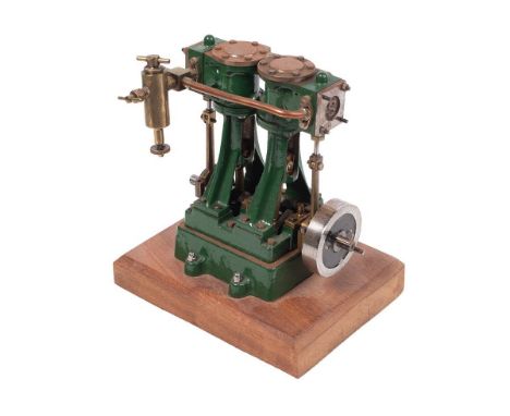 A Stuart Turner stationary two piston marine engine mounted on a wooden plinth. Height 17.5cm.  Engine turns as it should, un