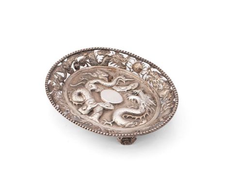 A Chinese export silver dish, of oval form, modelled with a dragon chasing the flaming pearl, the pierced rim with further pa
