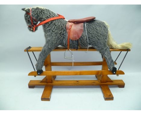 A "PEGASUS TOYS" ROCKING HORSE, hair effect upholstered, with leather saddle, on trestle frame, 96cm high 