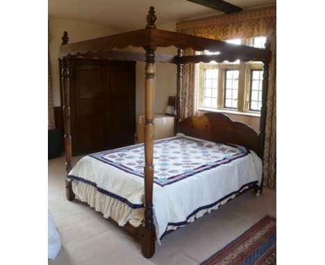 A 20TH CENTURY STAINED PINE FRAMED FOUR-POSTER BED, having turned posts with shaped headboard, 173cm wide x 220cm x 224cm hig