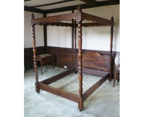 A 20TH CENTURY STAINED PINE FRAMED FOUR-POSTER BED, having turned posts with shaped headboard, 154cm wide x 209cm x 224cm hig