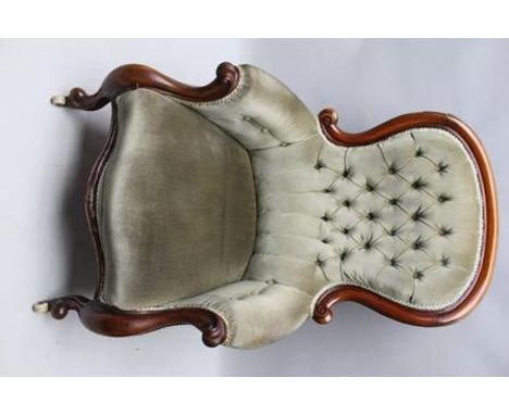 A VICTORIAN MAHOGANY SHOW-WOOD FRAMED BUTTON BACK EASY CHAIR having scrolling arms, green fabric upholstered, on cabriole for