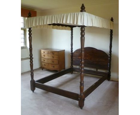 A 20TH CENTURY STAINED PINE FRAMED FOUR-POSTER BED, having turned posts with shaped headboard, 170cm wide x 215cm x 227cm hig