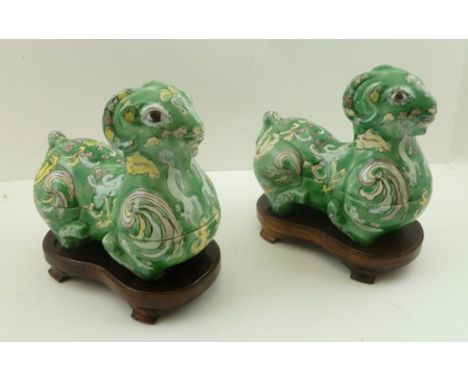 A PAIR OF CHINESE CERAMIC BOXES WITH COVERS, moulded in the form of rams, enamelled in lavender and yellow on a green ground,