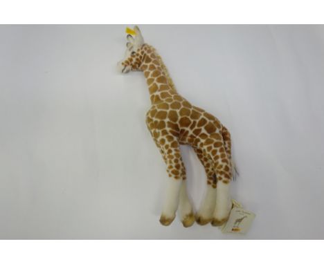 A modern Steiff plush giraffe, button label in ear and original tags.