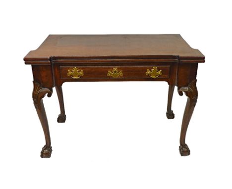 A George II mahogany card table, the rectangular fold-over top with outset corners and wells for counters, frieze drawer, on 