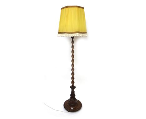 A walnut spiral column standard lamp, first half 20th century, the lotus carved pillar on a circular base, with shade.