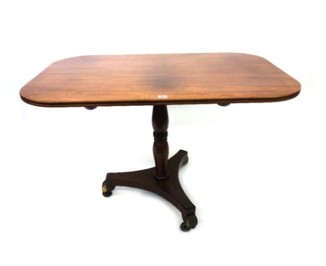 An early 19th century mahogany pedestal table, the rectangular tilt-top with rounded corners, on an associated ring turned pi