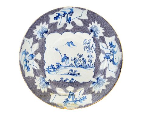 A Bristol delftware plate, circa 1760, the centre painted in blue with an oriental in a garden inside four panels of a figure