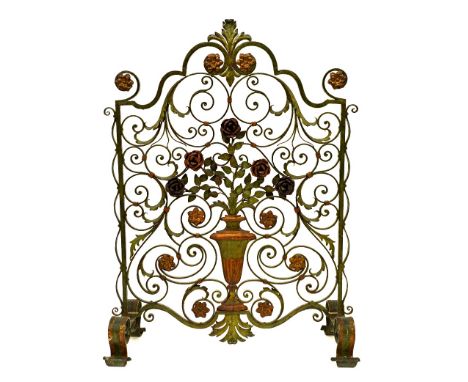 An ornate polychrome painted green wrought metal fire screen, early 20th century, of scrolling form centred by a classical va