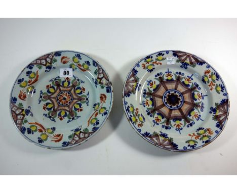 Two Lambeth delftware plates, circa 1790, of 'Ann Gomm' type, each painted in polychrome enamels with a central rosette insid